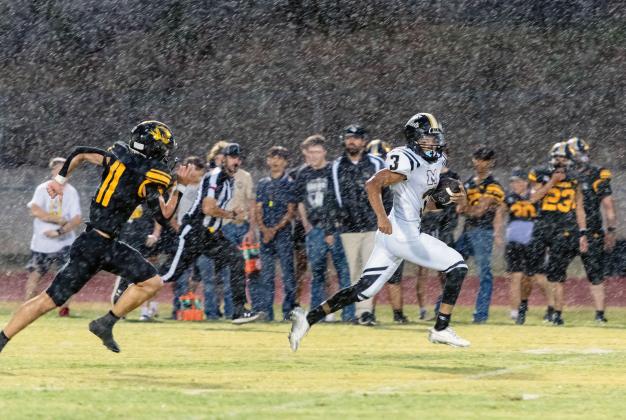 Yellowjacket Jayden Payton, #3, breaks through the Blanket defense for a touchdown during Friday's first -and rainy- football game of the season. After a couple of lightning delays the game was eventually called with 3:38 remaining in the second quarter, the score tied 14-14. Be sure to view this photo in color at menardnews.com. Nora Davis, photo.