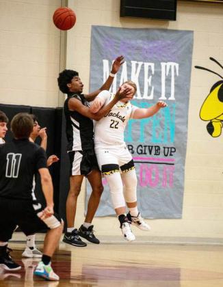 YELLOWJACKET Tate Wagner gets a faceful from a San Angelo Saint in Tuesday's boys basketball game. Menard fell to the San Angelo Saints 25-54. The Saints are part of the San Angelo Homeschool Sports Assc. See full schedules and additional photos on pages 8 and 9. Sandy Kothmann, photo.