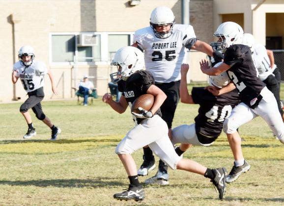 RUNNING TOWARD 6- Wesley Compton (standing), and Caden Carpenter #40, help to clear the way for seventh grader Mack Davis’s break for the goal line during a junior high showdown against Robert Lee earlier this season.
