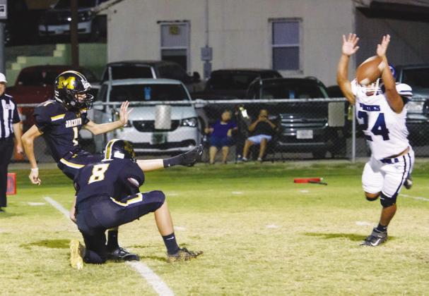 PERFECTION- Senior Roy Brown executes one of his nine successful PATs during Menard’s 72-13 blowout Homecoming win against Nueces Canyon Friday night. Fellow Yellowjacket Logan Powell (8) holding the ball. Nora Davis, photo.