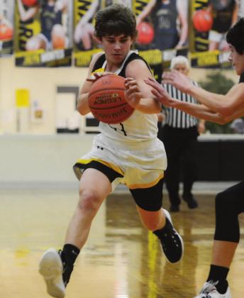 LEFT- Menard’s Kade Rayburn works the ball down the court in the Jackets’ win against Paint Rock last Friday. Sandy Kothmann, photo.