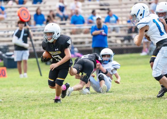 Sixth-grade Junior Jacket Walker Hines picks his way through the Eden Bullpup defense last Thursday in the Jr. Jackets win over Eden JH. Eight-grader Karson Mayfield helps clear the way. MHS JV also came out on top when the game against Eden JV was called for weather. See more Yellowjacket football on page 9; photos on page 10. Nora Davis, photo.