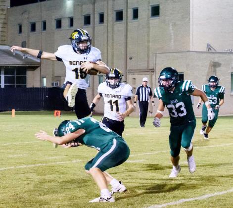 FLIGHT 15- Senior Yellowjacket Joel Guerrero fully hurdles a San Marcos Academy defender during the football game last Thursday. Junior Wyatt Terrell (11), provides backup. Despite Guerrero’s incredible stats, the Jackets fell to SMA 57-68. Nora Davis, photo.