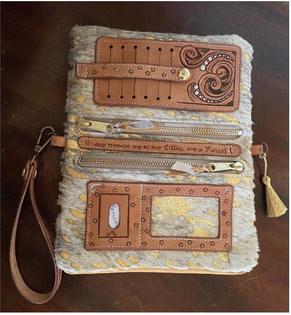 An inside view of the clutch Mews handcrafted for the contest. Complete with 6 card slots, a place for an ID, two zippered pouches and more. The middle leather strip is tooled with her favorite saying, “And although she be Little, she is Fierce.”