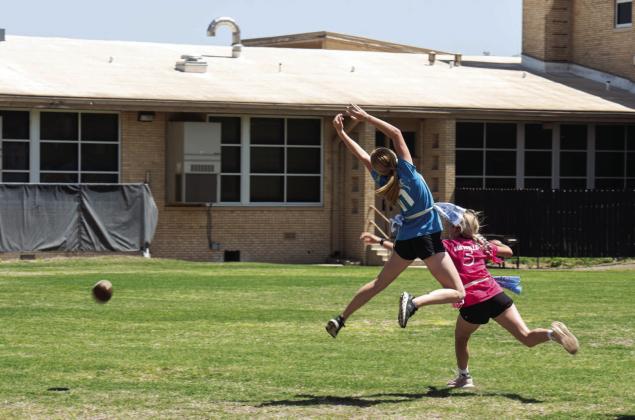 Senior receiver Addy Bannowsky makes a move to catch the pass, while avoiding defender Korah Mayfield. The play resulted in this dramatic photo by Sandy Kothmann. Fortunately for the football, it escaped the players, virtually untouched! (See left side of photo)