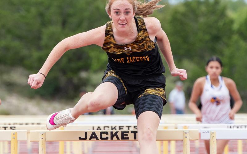 LEFT- Isabelle Devine powers past a Rochelle opponent to win second place in the 200m dash at the district meet last week. BELOW- The Floyd Teague to Brayden Ramon handoff in the boys 4x400m relay. The team of Bounds, Teague, Ramon and Davis finished in second place.