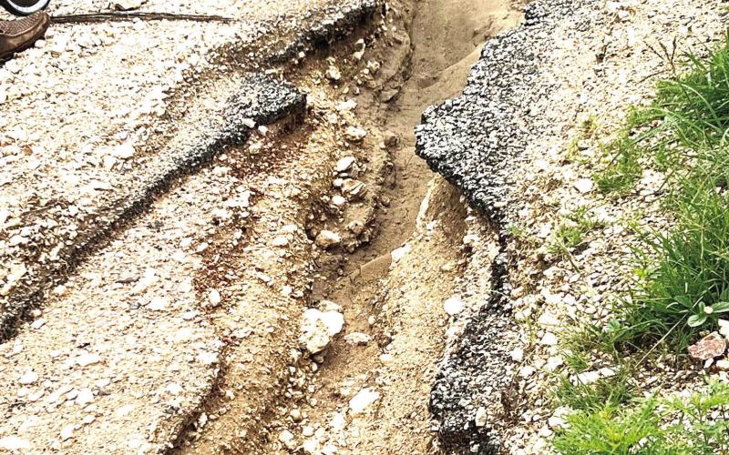 ABOVE: One of many examples of the flood damage at Pioneer Rest. Eroded pavement, soil, and material exists throughout the Pioneer Cemetery, making it impassable for vehicles. Courtesy photo.