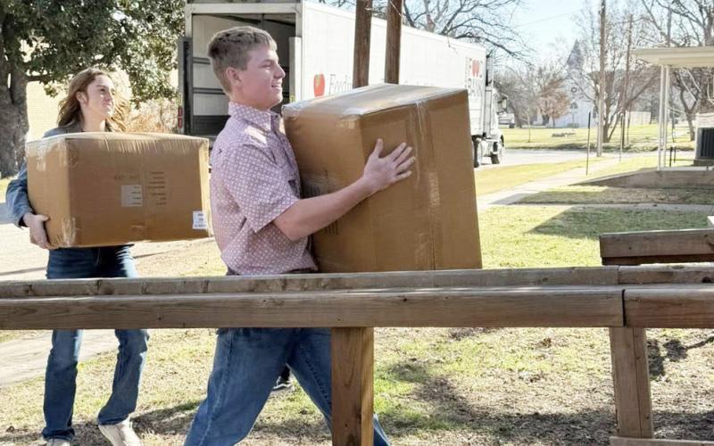 LEFT- Makenzie Wright and Kade Bannowsky haul grocery items into the Hope House during a recent