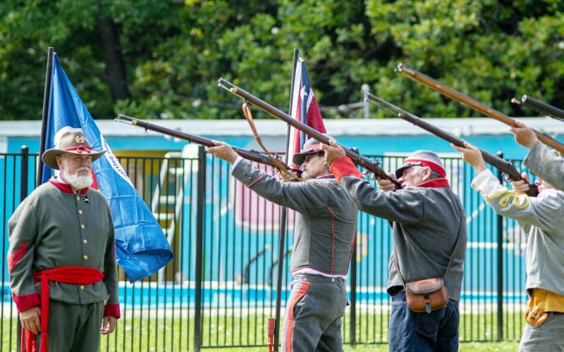 LEFT- Commanded by Barry Kniffen, left, the local chapter of Sons of Confederate Veterans (SCV) performed military honors via firing party utilizing period muskets on Monday at the annual Memorial Day Observance at American Legion Park. Pictured firing, left to right is Wayne Carlile, Danny Masters, Bayden Fleming. Sandy Kothmann, photo.