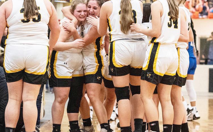 Lady Jackets Mackenzie Wagner and Makinley Kothmann, center, hug in celebration of their 'redemption' win over Eden last week. The outcome resulted in Menard and Eden being named district co-champions. Sandy Kothmann, photo.