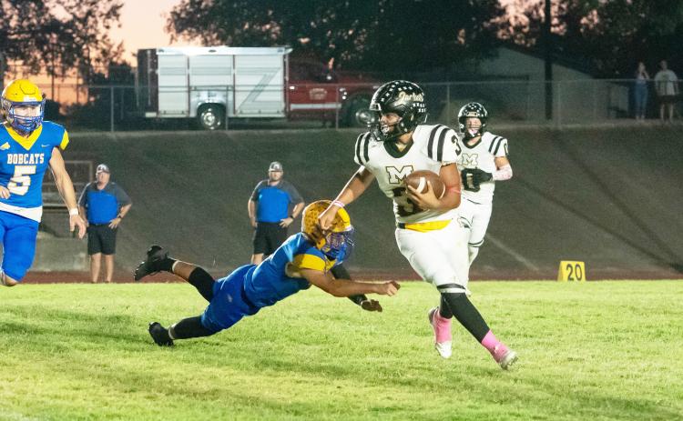 THREE FOR THE MONEY- Senior Jayden Payton (#3) eludes a Medina Bobcat during the Jackets' 62-40 district win last week. Medina,now 6-2 on the season and 1-1 in district, started out the game scoring on the first play of the game. The competition was uncomfortably close throughout the first half, before Menard was able to pull ahead and get the win to become 2-0 in district. Nora Davis, photo.
