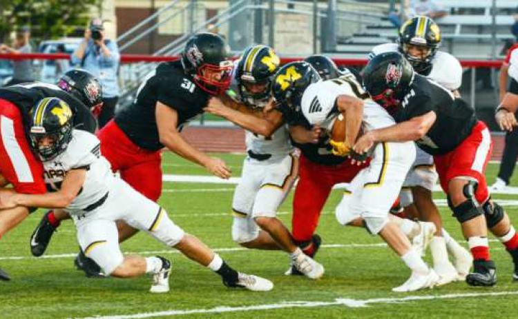 A swarm of Yellowjackets work to clear a path in last Friday’s game in Garden City.