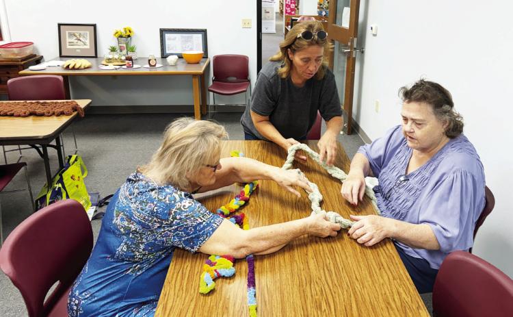 MENARD KNITTY GRITTIES CRAFT GROUP- Kathy Ryan, Christi Sanders and Dianne Simmons learn to finger knit with chunky yarn at the library's first arts and crafts gathering. The class meets on Thursday mornings, aside from the fourth Thursday of each month. For more information contact the library at 325-396-2717. Courtesy photo.