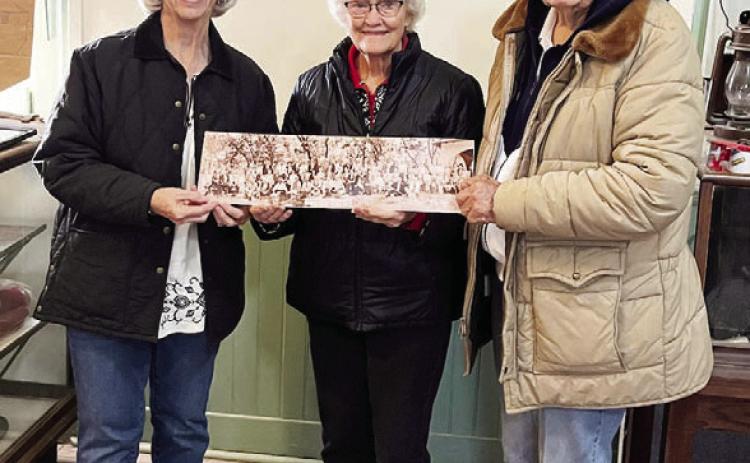 MUSEUM ADDITION- Judy Stewart (pictured left) and husband Craig (not pictured) recently donated a photo to the Menardville Museum collection. The print features Texas Rangers gathered during their 1927 summer meeting in Menard. Judy's grandfather is believed to be in the photo. Katherine and John Kniffen, pictured, accepted the photo of the museum which is now reopened after a brief reorganization. Courtesy photo.