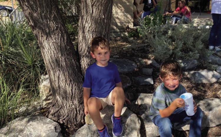 Clover kids Haiden Hand and Deacon Compton stop to enjoy a free snow cone at Tuesday’s Menard 4-H Enrollments rally. The library and gardens were teeming with activity as adult leaders helped guide youngsters to 4-H activities they could choose to join. Courtesy photo.