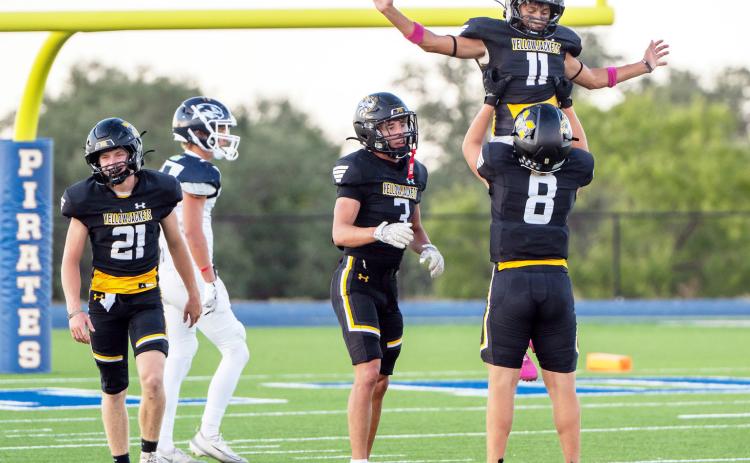 ABOVE- Mack Davis lifts Maddox Saiz in c e l e b r a t i o n of Kade Bannowsky (far left) blocking a Falcon punt, resulting in a safety. Cohen Ethridge joins in.