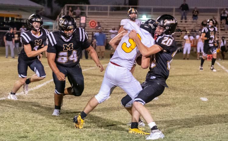 LET’S DANCE- Senior Bryce Davis (#20) lovingly brings down a Tiger ball carrier in Fridays Yellowjacket win over Blanket. Zeke Hernandez (#64) and Eli Weatherly (#4) are also pictured.