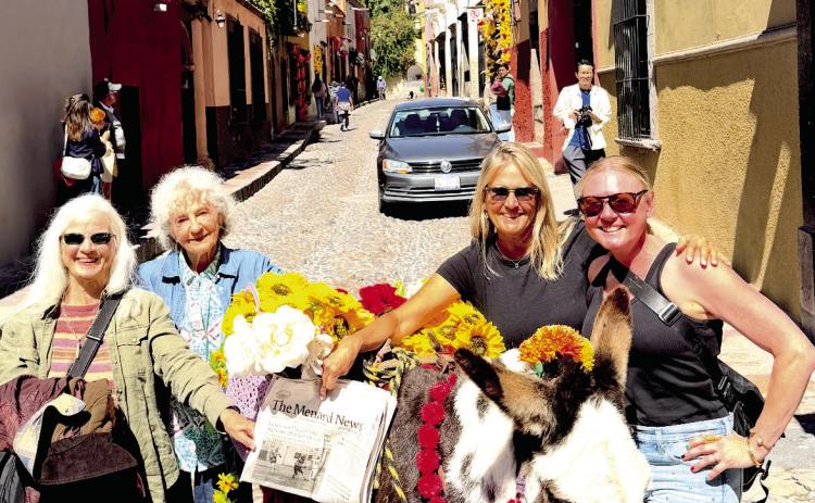 The lovely ladies, (L-R) Vicki Davis Olson, Linda Ray Myers, Susan Porter Miller and Caroline Starry, posed with a burro on Aldama Steet while the Parroquia de San Miguel Archange was visible in the background. Courtesy photo.