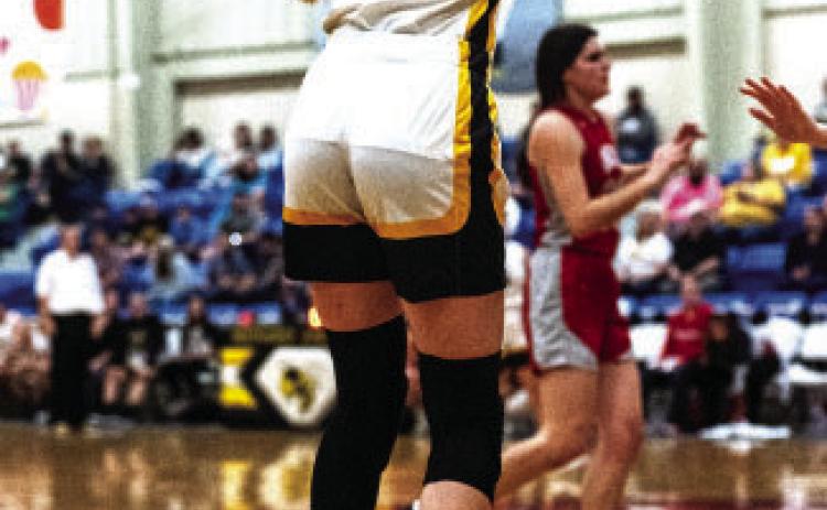 Senior Addy Bannowsky shoots a three, in a game that reselmbled a battlefield at times, against Miles.