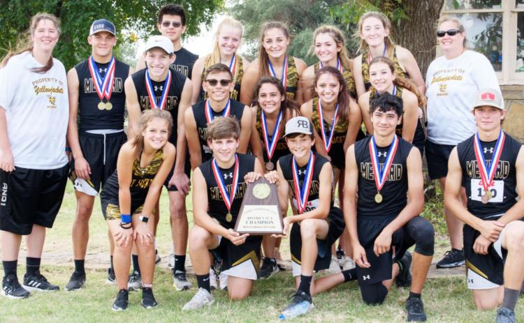 CHAMPS!- MHS cross country teams, with the boys displaying their district champion trophy. L-R, front: Chloe Whitson, Kade Rayburn, Roy Brown, Kolton Whitaker, Houston Hayes. Middle row: Wyatt Terrell, Kevin Johnson, Tatum Ruiz, Hailey Ruiz, Kendal Lawler. Back row: Coach Samantha Bell, Joel Guerrero, Christian Condarco, Addy Bannowsky, Makinley Kothmann, Korah Mayfield, Ayden Matlock, Coach Nancy Saller. Nora Davis, photo.