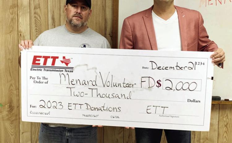 Assistant Fire Chief Jeff Whitson, left, accepts a VFD donation from Eddie Pallarez on behalf of Electric Transmission Texas (ETT).