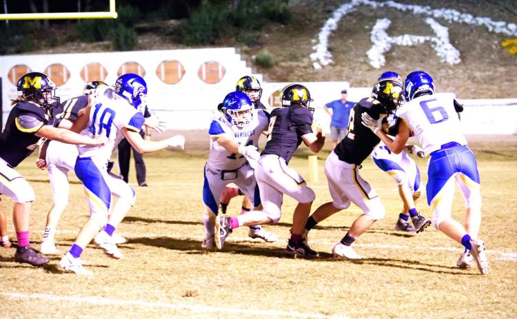 FINDING HIS WAY- Junior Hunter Whitaker, center, finds a hole and rushes in for a Menard touchdown against Veribest last Friday night. William Doyle blocks to the right, and Kade Rayburn helps out to his left. Brandon Spinks and Wyatt Terrell keep defenders at bay from the back side. Nora Davis, photo.