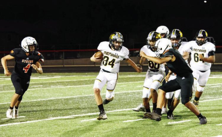 Menard freshman Tucker Pullen, center, works his way around a Robert Lee defender during the JV game last Thursday.