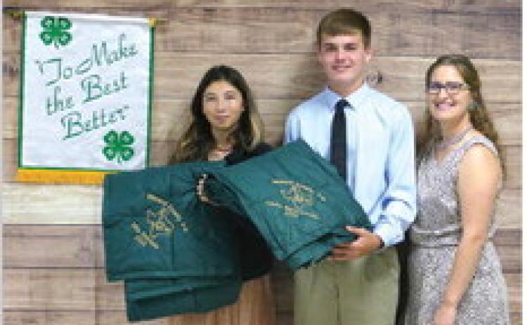 GOLD STARS ALL AROUND! Mia Estrada, left, and Cado Bannowsky accept their prestigious Gold Star Awards at the awards banquet. The Gold Star is the highest honor bestowed upon a 4-H member. Also pictured is 4-H Coordinator Haley Anderson. See additional awards banquet photos on page 7. Photo courtesy Menard 4-H.
