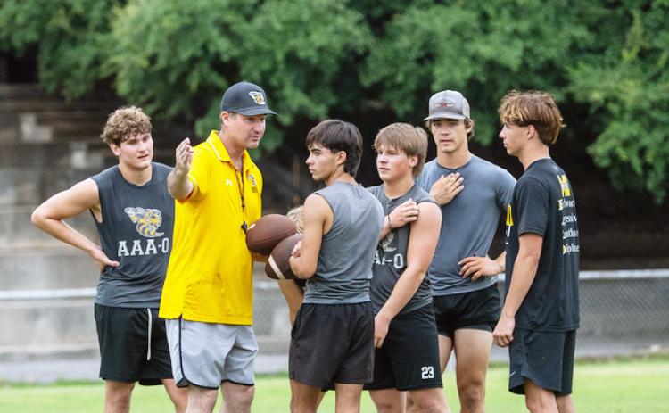 HEAD COACH Clay Holland instructs a group of Yellowjacket football players in preparation for the 2026 season. Pictured left to right: Caden Bounds, Holland, Julius Zamora, Mack Davis, Wesley Compton, Cohen Ethridge. Nora Davis photo.