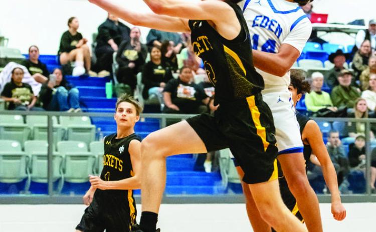 YELLOWJACKET Eli Weatherly, center, fights a Bulldog for the bucket during Menard's 50-13 routing of Eden last week. Jaegar Leonard in background. Nora Davis, photo.