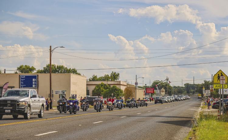 The community stood in somber respect as several agencies escort 19-year-old Lance Corporal Kendal Lawler home for burial in Menard last week. Photo by Cheyanne Nance.