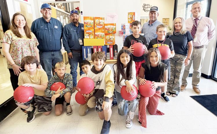 PEC DONATES SUPPLIES- Elementary teacher Myghan Meadow, far left, and principal Cody Holubec, far right, stand with grateful students and Junction PEC District Director Craig Molina, Alex Gonzales and Travis Brown. TMN photo.