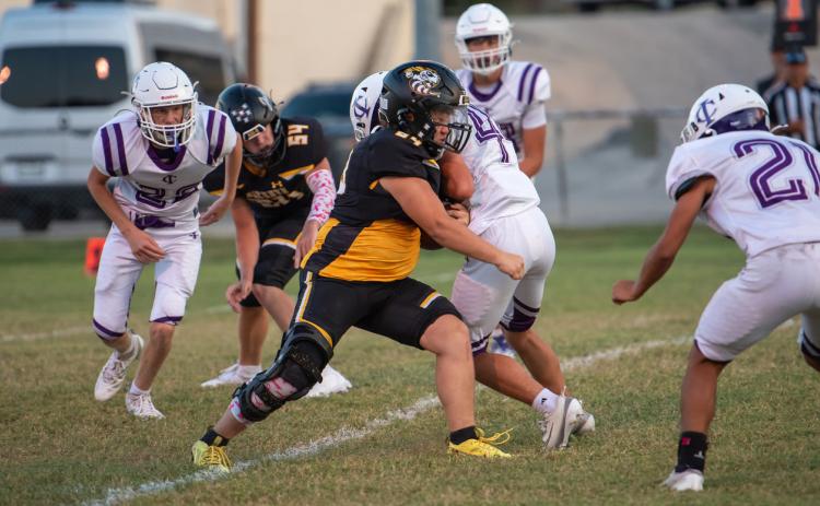 TOUCHDOWN, SQUIERS! Senior Yellowjacket Korbin Squiers, center, battled through with his Menard JV counterparts against a tough Irion County JV team last week to score the first touchdown of his high school career. Sophomore Benjamin Burch (#54) looks on. Menard came out on top 54-8. See additional photos on page 8. Nora Davis, photo.