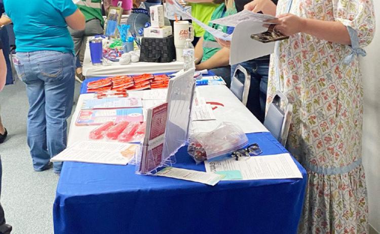 Frontera's Rosanna Roberson and Menard Chamber's Cherry Swindall look over materials available at last week's first-responder- centered events. Courtesy photo.