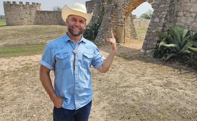 The Daytripper Chet Garner stands at the entrance of the Presidio de San Saba during his show’s filming of Menard. Photo by The Daytripper.