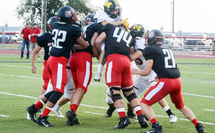 IN A BIND- Menard’s William Doyle, center, braces for impact from 5 of Garden City’s 6 players on the field in Friday night’s game. Attempting to assist Doyle is senior Joel Guerrero. (#15). The Yellowjackets suffered a 8-54 loss with a 45 mercy rule ending the game in the third quarter. Sandy Kothmann, photo.