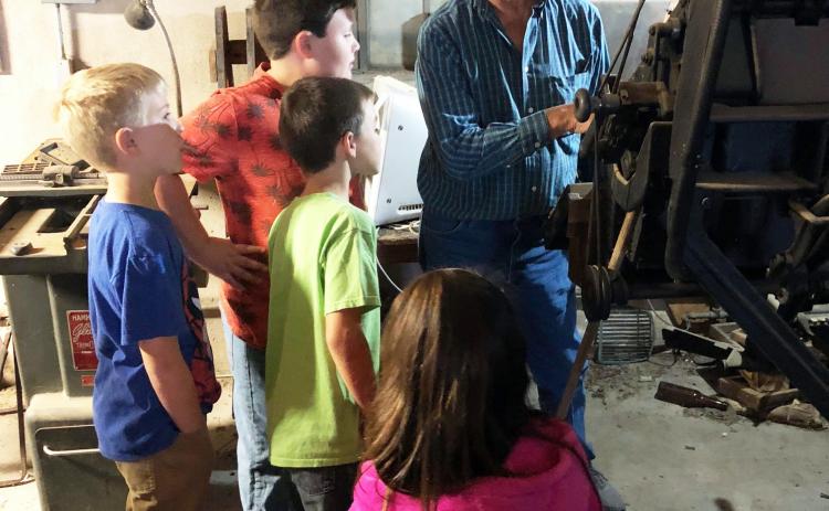 ABOVE- Dan never fully stepped away from the news office upon retirement, whether we suggested it or not. Above he is explaining the original printing equipment to some elementary Gifted &amp; Talented students in 2018. Those kids are juniors in high school now- Kinsley Carlile, Benjamin Burch, Wesley Compton, Noble Porter. TMN photo.