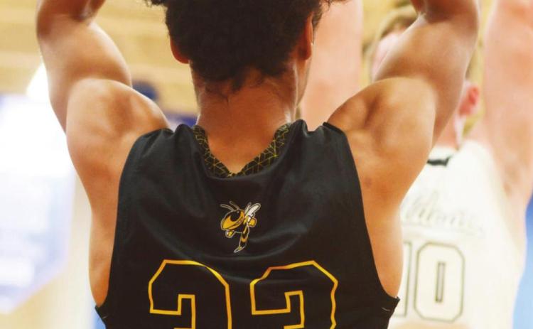 LEFT- Junior Isaiah Stanislawski searches for a clear pass in Menard’s playoff loss against Water Valley on Monday, Feb. 21. Photo by Sandy Kothmann.