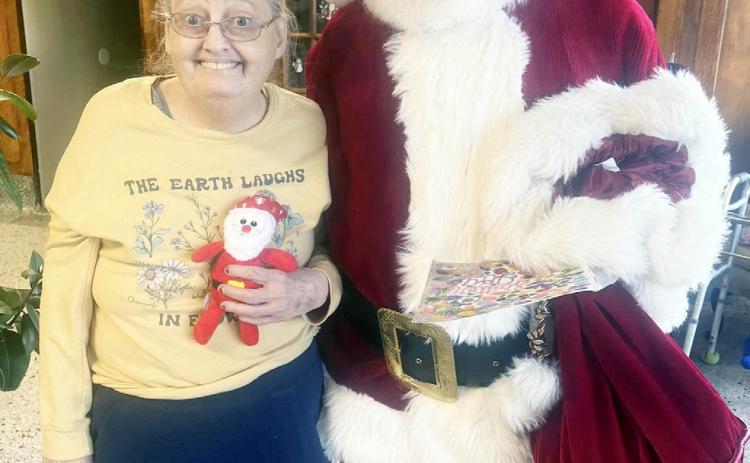 MUCH TO THE DELIGHT of Menard Manor resident Pennye White, Santa made time to stop by the Manor during his Saturday visit. Pennye is a big fan of the Big Guy! Courtesy photo.