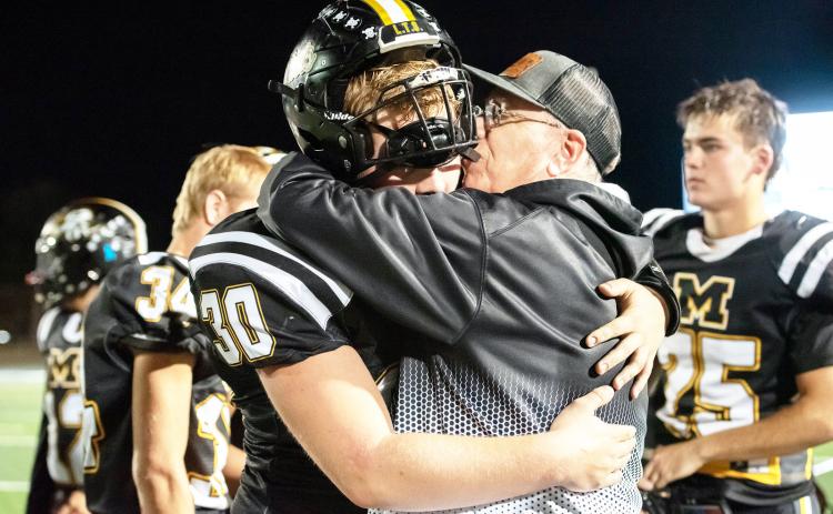 Beloved Menard coach Jeffrey Campbell, right, consoles junior Tate Wagner (#30) after the Jackets' loss to #1 Gordon last week in the area playoff round. Menard was yet another victim in the Gordon Longhorns undefeated season. The defending state champs, Gordon, has not played a third quarter in more than 2 seasons, as they tend to 45 their opponents by the half. This group 45'd fellow 6-man powerhouse Westbrook last year in the state championship. Nora Davis, photo.