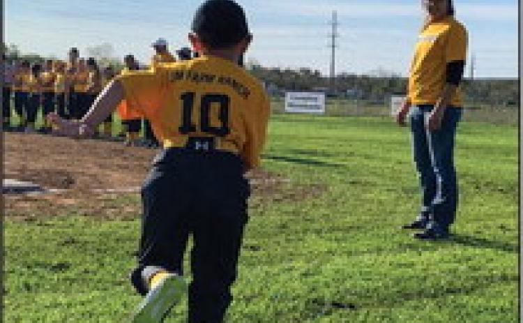 HERE WE GO! Number 10 joins his team on the Menard Youth Baseball field during opening ceremonies Saturday. Volunteer coach/player wrangler Deidra Waggoner stands by. MYB has 11 total baseball and softball teams this year. Ages range from 3 years up to 14. Games are played both in Menard and surrounding towns. TMN photo.