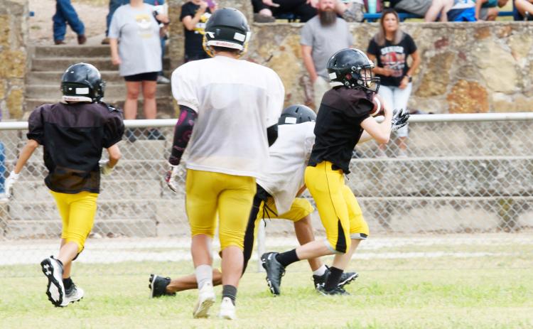 I’LL TAKE THAT- Menard’s Bryce Davis, far right, slips away with an interception during the Yellowjackets’ football scrimmage in Rochelle last week. The team faces Hill Country Christian at home on Thursday, August 25 in their first offocoal game as a six-man team. TMN photo.