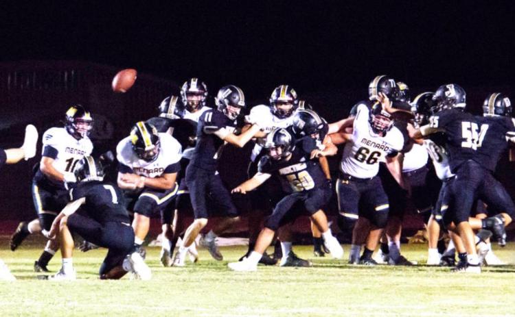 NOT TODAY, EAGLES! Senior Zadrian Zapata (#21, head down) busts through Junction’s line to block their point after. The denial of this extra point ended up being the game-winner in Menard’s 7-6 win Nora Davis, photo.