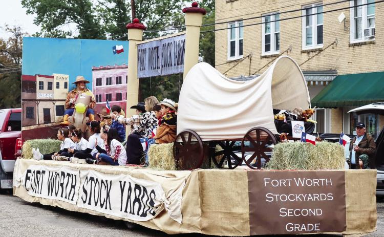 SECOND GRADERS and their teachers, Amy Allison and Gwenda Neel, ride atop their grand champion float in Saturday's annual PTO Veterans Day Parade. This year's parade boasted 33 total entries. The cool wet weather did not deter the crowds; the streets were packed with parade watchers. Laressa Brown, photo.