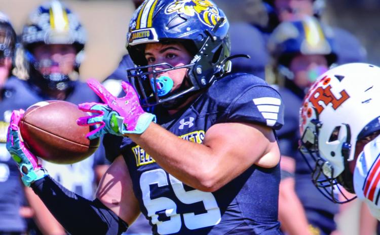 Senior Jadon Torres gets a hold on the ball during the Yellowjackets first district game against Robert Lee.