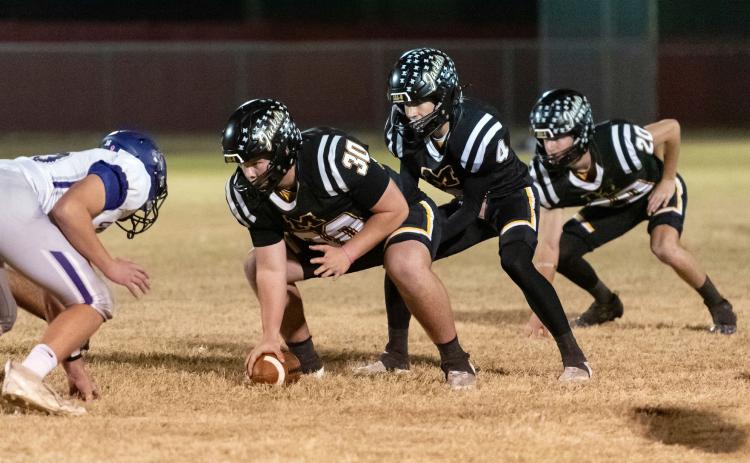 BI-DISTRICT BLOWOUT- Senior Tate Wagner, junior Eli Weatherly, and senior Bryce Davis line up prior to a snap last Friday against Knippa in Rocksprings. The Jackets mercy-ruled the Rockcrushers 62-0 by the half. Playoff week 2 sees Menard face Gordon, the reigning state champion of Class A, Div. 1. See area round playoff info below or on page 8. Nora Davis, photo.