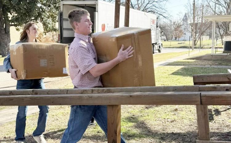 LEFT- Makenzie Wright and Kade Bannowsky haul grocery items into the Hope House during a recent