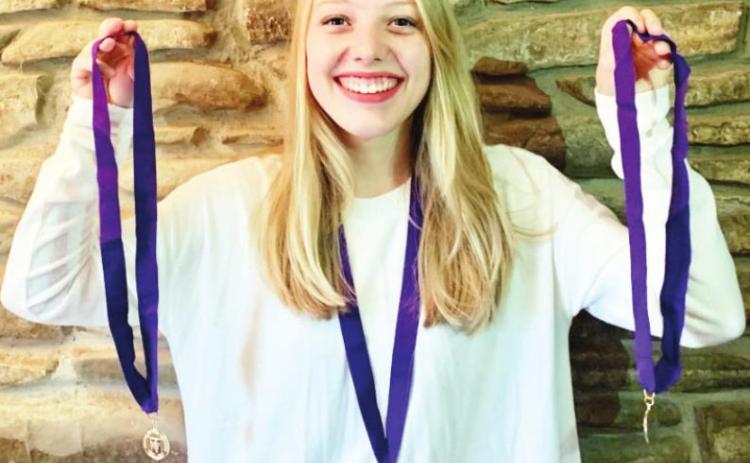 AD VICTORIAM- Menard teenager Zea Prest displays her three medals from her three consecutive years of earning Gold Summa Cum Laude distinction in the national Latin Exam. Courtesy photo.