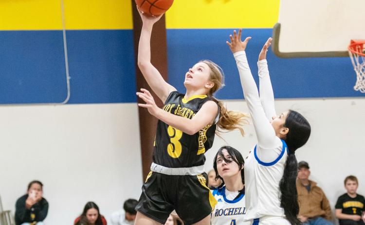 BELOW- Marlee Salas lays it up in the Jackets' 90-18 district win over Olfen on January 30. Julius Zamora (#10) and Eli Weatherly (#2) pictured foreground. RIGHT- Isabelle Devine goes for 2 in the Menard girls' 64-18 victory over Olfen on Jan. 30. The Lady Jacket win over Eden this week has secured their district title. Photos by Nora Davis. Additional basketball photos on page 8.