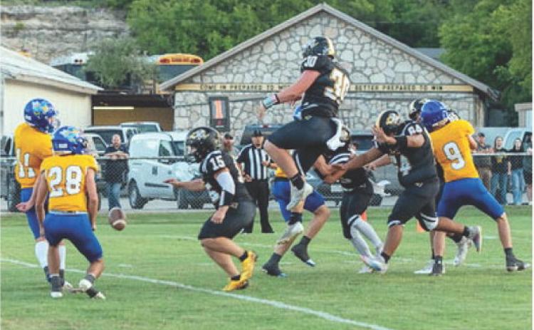 FIGHTIN' BACK- Menard's Tate Wagner defies gravity to block a Rochelle PAT in last Friday's 34-83 loss to Rochelle. Nora Davis, photo.